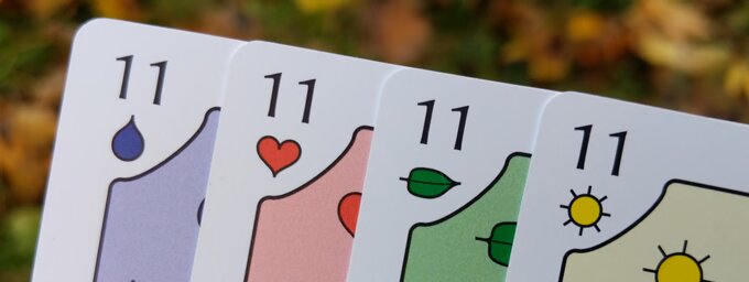 The four Eleven cards fanned out, one per suit: Blue, Red, Green, Yellow